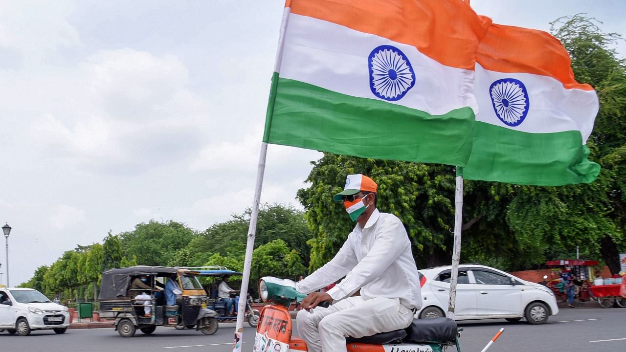 A man rides a scooter painted in the tri-colour ahead of Independence Day. Credit: PTI Photo
