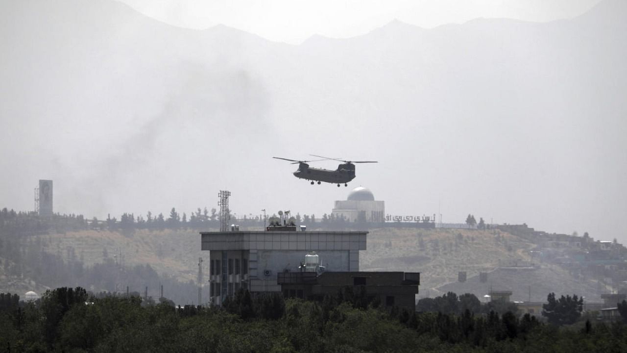 A U.S. Chinook helicopter flies over the U.S. Embassy in Kabul, Afghanistan, Sunday, Aug. 15, 2021. Helicopters are landing at the U.S. Embassy in Kabul as diplomatic vehicles leave the compound amid the Taliban advanced on the Afghan capital. Credit: AP Photo