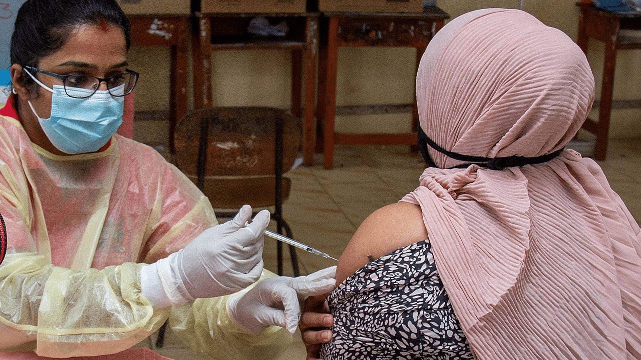 A health worker administers a first dose of the AstraZeneca Covid-19 vaccine to a woman in Suva. Credit: AFP Photo