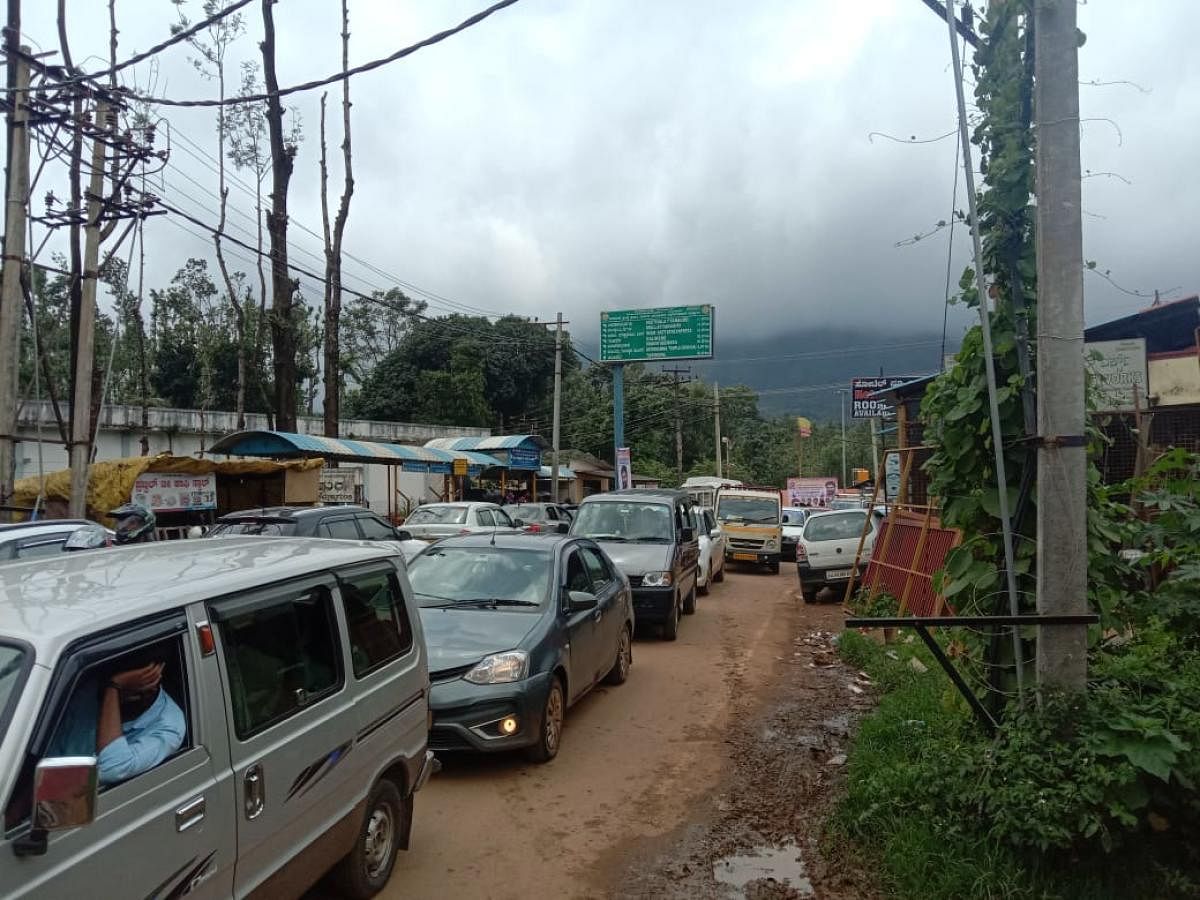 Vehicles stranded in a long queue at Kaimara check post in Chikkamagaluru. Credit: DH Photo