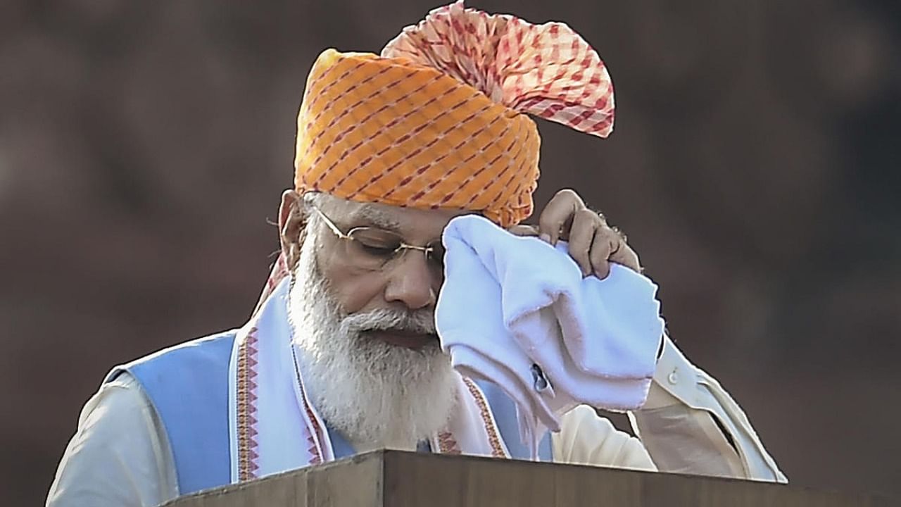 Prime Minister Narendra Modi wipes sweat from his forehead as he addresses the nation, during the 75th Independence Day function at the historic Red Fort, in New Delhi. Credit: PTI Photo