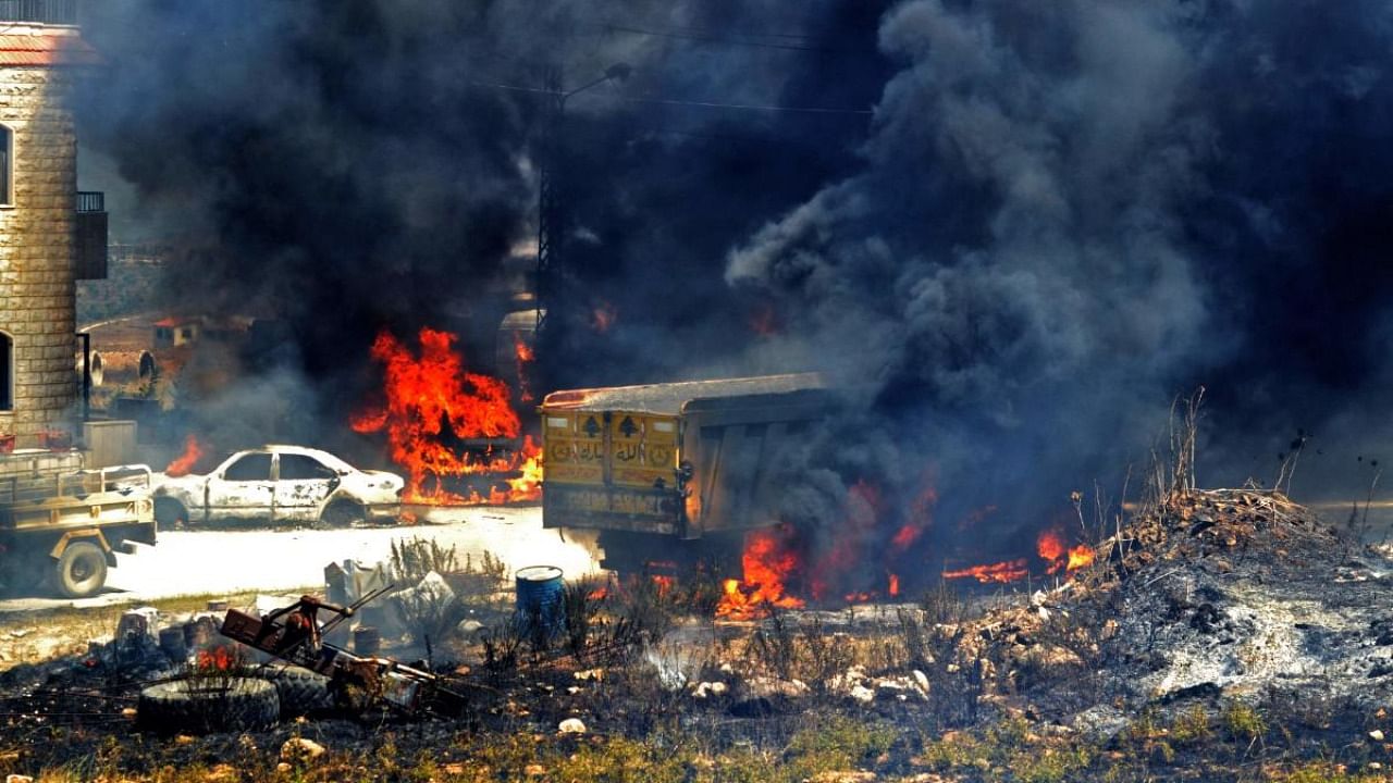 Vehicles burn outside the reported home of the lot owner, where the exploded fuel tank was placed, in the village of Tlel in Lebanon's northern region of Akkar on August 15, 2021. Credit: AFP Photo
