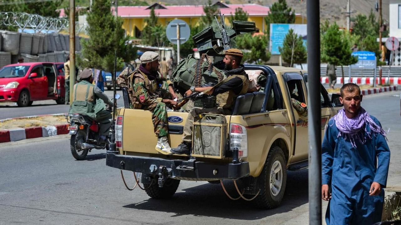 Soldiers from Afghan Security forces travel on a armed vehicle along a road in Panjshir province of Afghanistan on August 15, 2021. Credit: AFP Photo