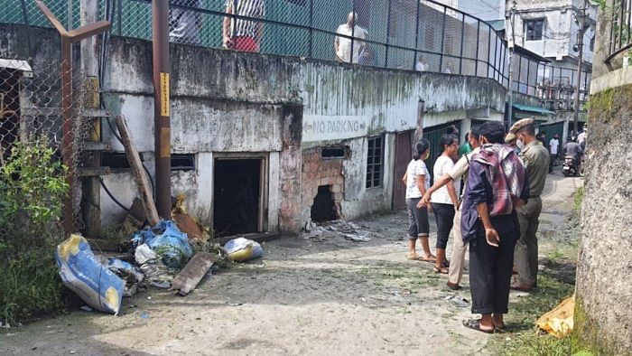 Police personnel stand near the site of an IED blast at Laitumkhrah market in Shillong. Credit: PTI Photo