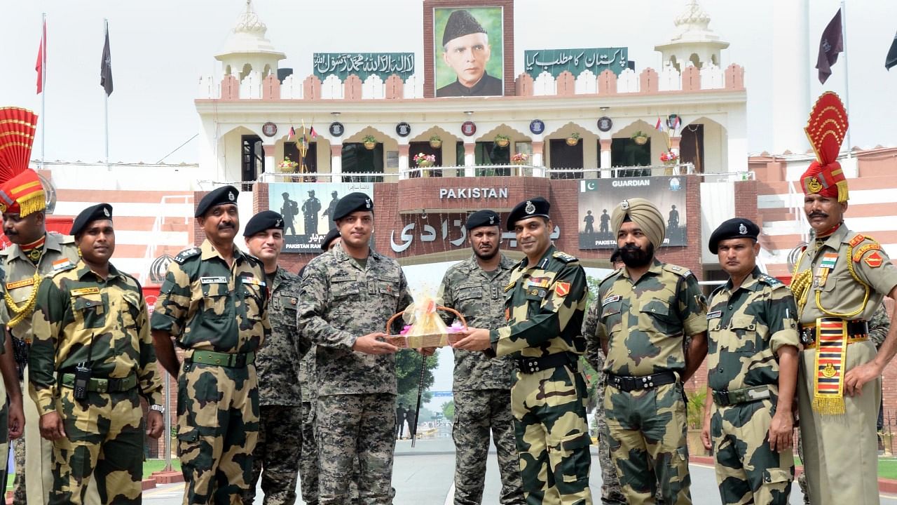 Border Security Force (BSF) Commandant Jasbir Singh presents sweets to Pakistani Wing Commander Hassan on occasion of India's 75th Independence Day, at the India-Pakistan Attari-Wagah border. Credit: PTI Photo