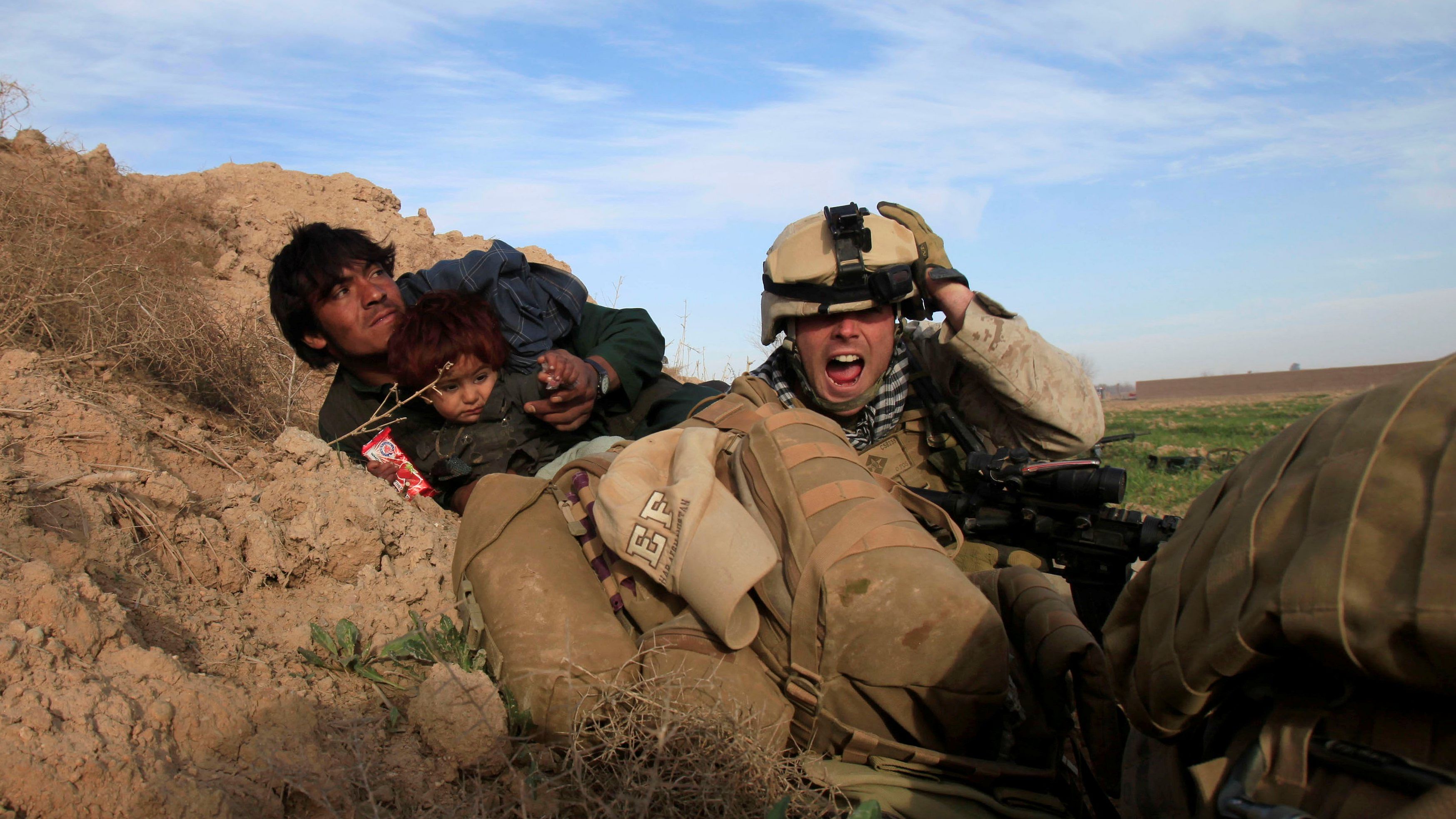 US Marine Lance Corporal Chris Sanderson, 24, from Flemington, New Jersey shouts as he tries to protect an Afghan man and his child after Taliban fighters opened fire in the town of Marjah, in Nad Ali district, Helmand province, Afghanistan February 13, 2010 . Credit: Reuters File Photo