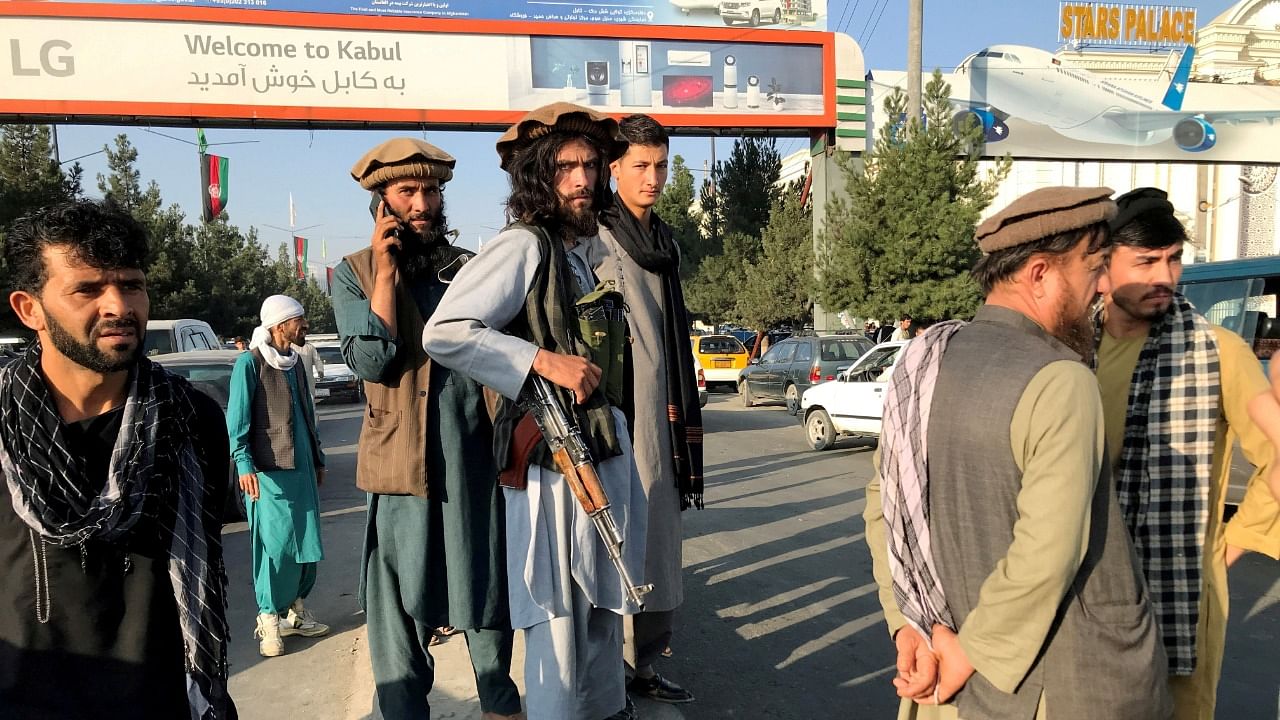 A member of Taliban (C) stands outside Hamid Karzai International Airport. Credit: Reuters Photo