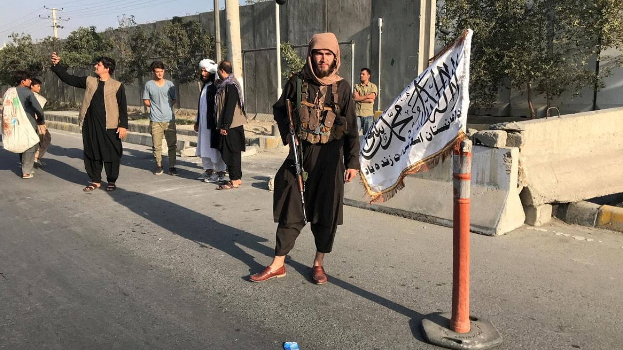 A member of Taliban stands outside the Interior Ministry in Kabul, Afghanistan. Credit: Reuters Photo