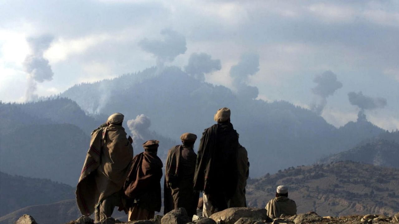 FILE PHOTO: Anti-Taliban Afghan fighters watch several explosions from U.S. bombings in the Tora Bora mountains in Afghanistan December 16, 2001. Credit: Reuters Photo