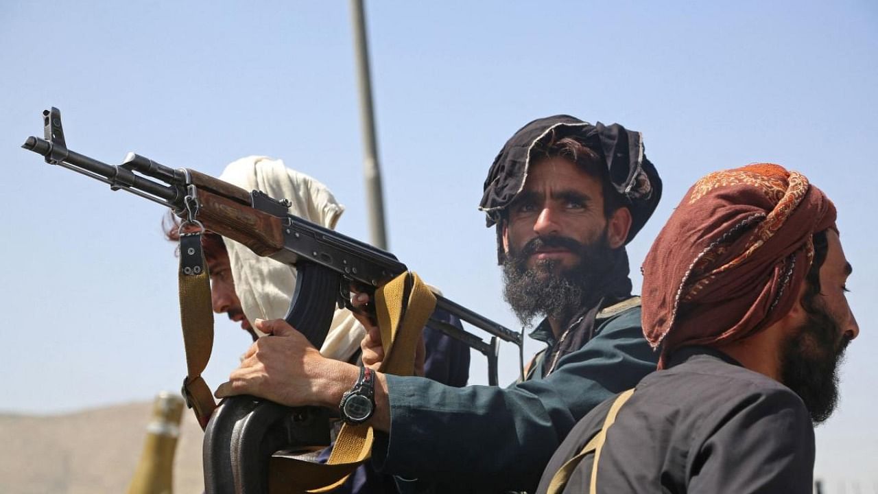 Taliban fighters stand guard in a vehicle along the roadside in Kabul. Credit: AFP Photo