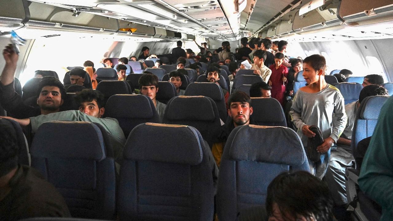 Afghan passengers sit inside a plane as they wait to leave the Kabul airport in Kabul on August 16, 2021, after a stunningly swift end to Afghanistan's 20-year war, as thousands of people mobbed the city's airport trying to flee the group's feared hardline brand of Islamist rule. Credit: AFP Photo