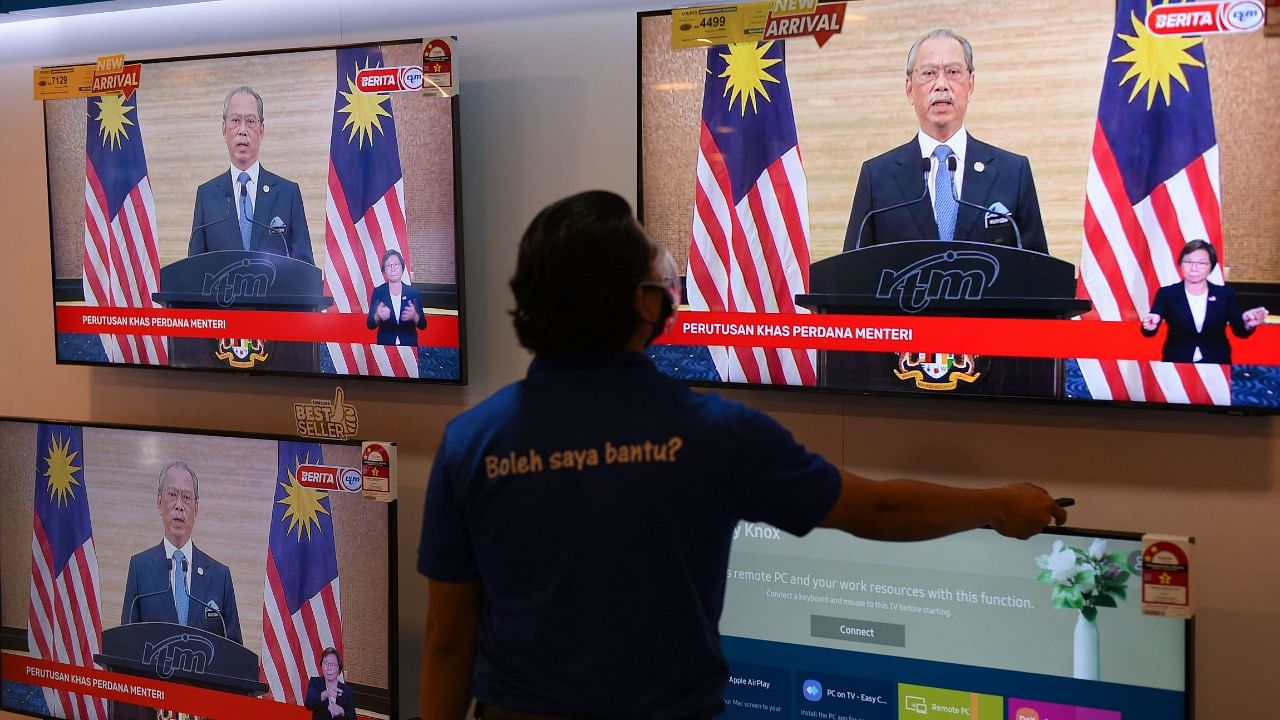 A man watches a television on display at a shopping mall store as Malaysian Prime Minister Muhyiddin Yassin announces his resignation as he addresses the nation during a live telecast in Kuala Lumpur. Credit: AFP Photo