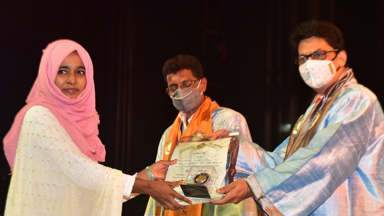 A student secures rank certificate and medal from Mangalore University Vice Chancellor Prof P S Yadapadithaya during the 39th annual convocation, at university campus in Mangalagangothri on Saturday. DH Photo