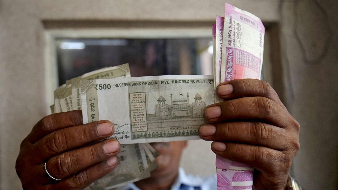 A man checks Indian rupee notes. Credit: Reuters Photo