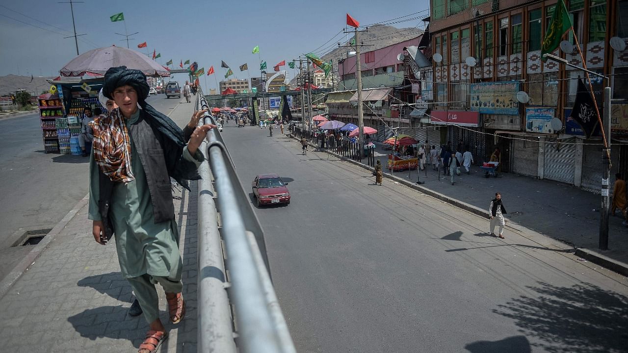 A local Afghan boy looks on while walking past an overbridge near a market place