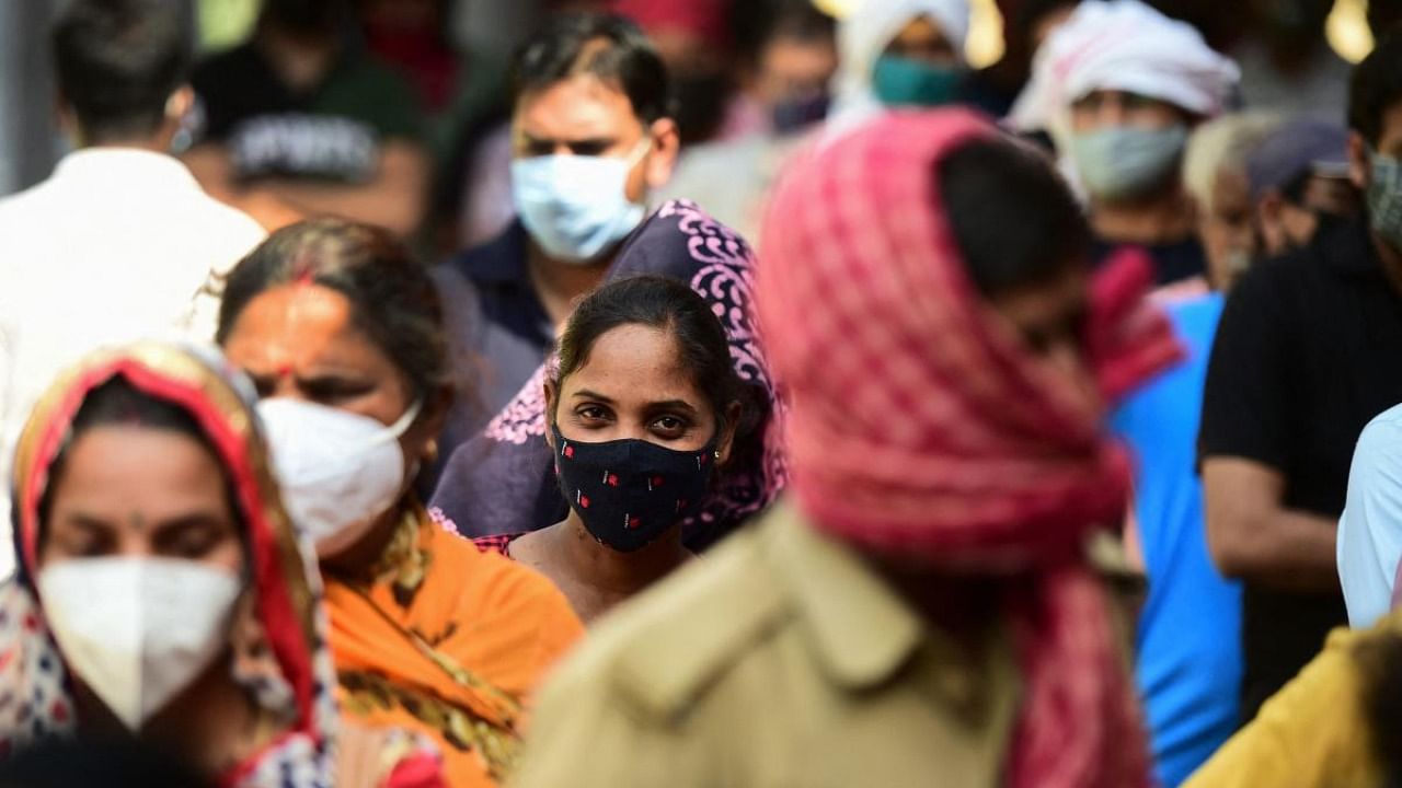 People stand in a queue to register for a Covid-19 coronavirus test, at a testing centre in Allahabad. Credit: AFP Photo