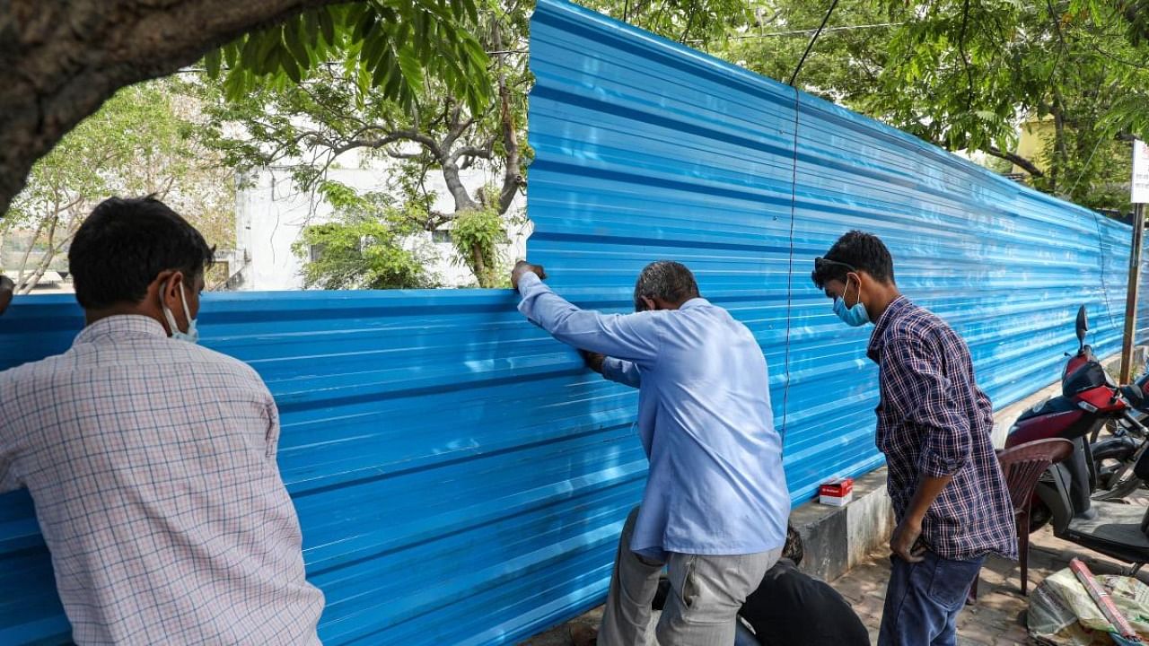 The Bhaisakund crematorium in Lucknow being covered with blue tin sheets on Thursday after its photo and videos showing a number of dead bodies burning went viral on social media, in Lucknow. Credit: PTI Photo