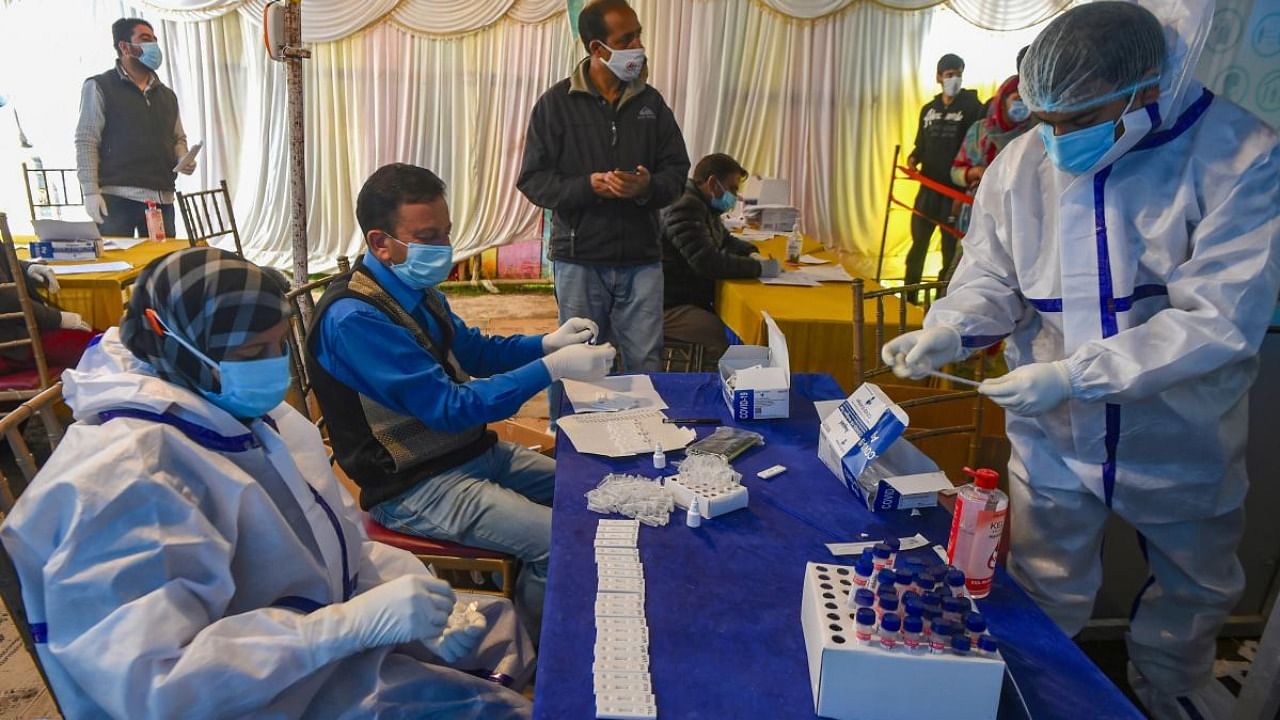 Health workers process Covid-19 antigen test samples as cases continue to surge across the country, in Srinagar. Credit: PTI Photo