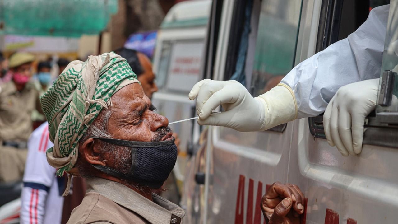 A medic collects swab sample for Covid-19 test, amid surge in coronavirus cases across the country, in Poonch. Credit: PTI Photo