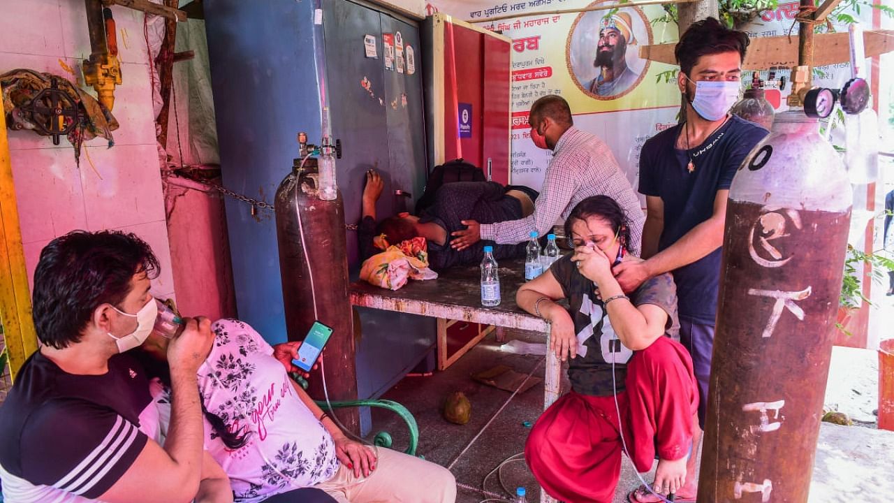 Critical Covid-19 patients receive free oxygen provided by a Gurdwara, amid rise in COVID-19 cases across the country, in Indirapuram, Ghaziabad. Credit: PTI Photo