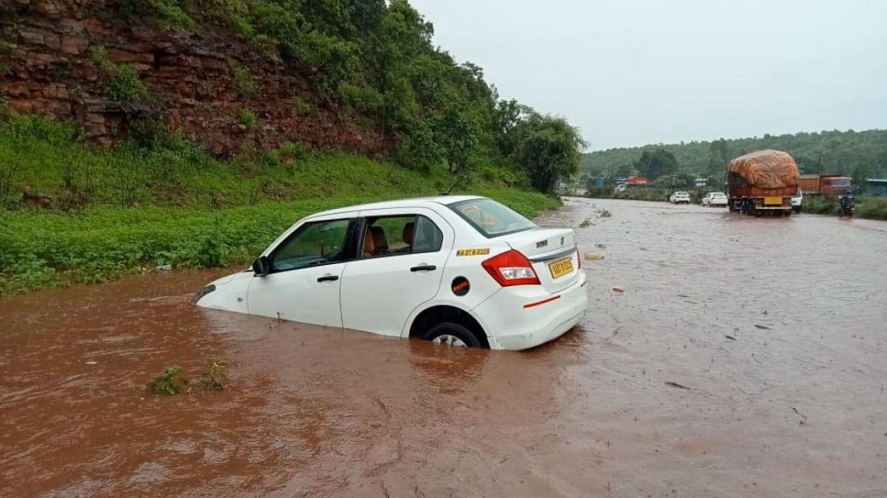 A car got stuck in a flooded Pune-Bengaluru highway (NH-4) at Vantamuri Ghat in Belagavi taluk on Thursday. Credit: DH Photo