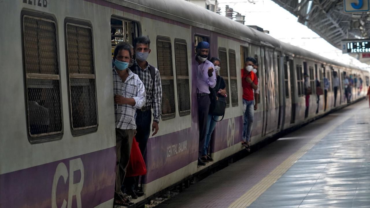 Commuters wearing protective face masks travel in a suburban train in Mumbai. Credit: Reuters Photo