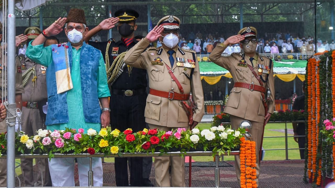 Lt Governor Manoj Sinha salutes after unfurling the Tricolor during 75th Independence day function amid heavy rains at Sher-e-Kashmir Cricket Stadium, in Srinagar. Credit: PTI Photo