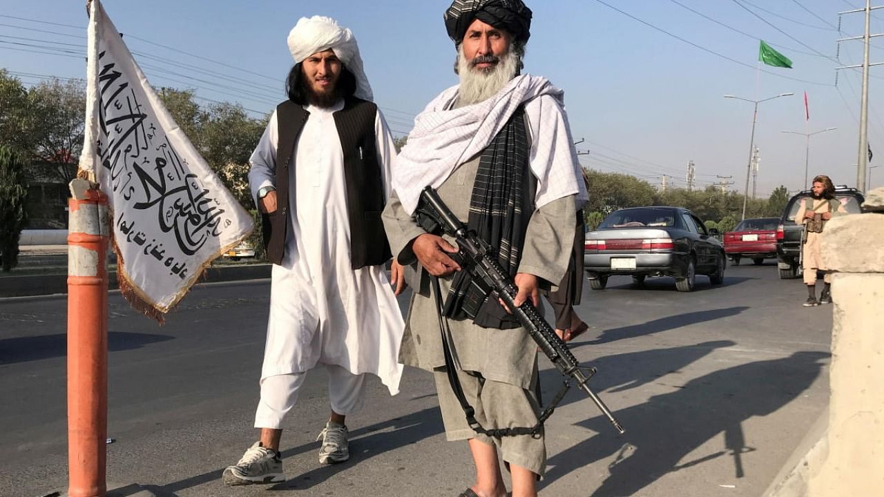 A Taliban fighter holding an M16 assault rifle stands outside the Interior Ministry in Kabul, Afghanistan. Credit: Reuters Photo