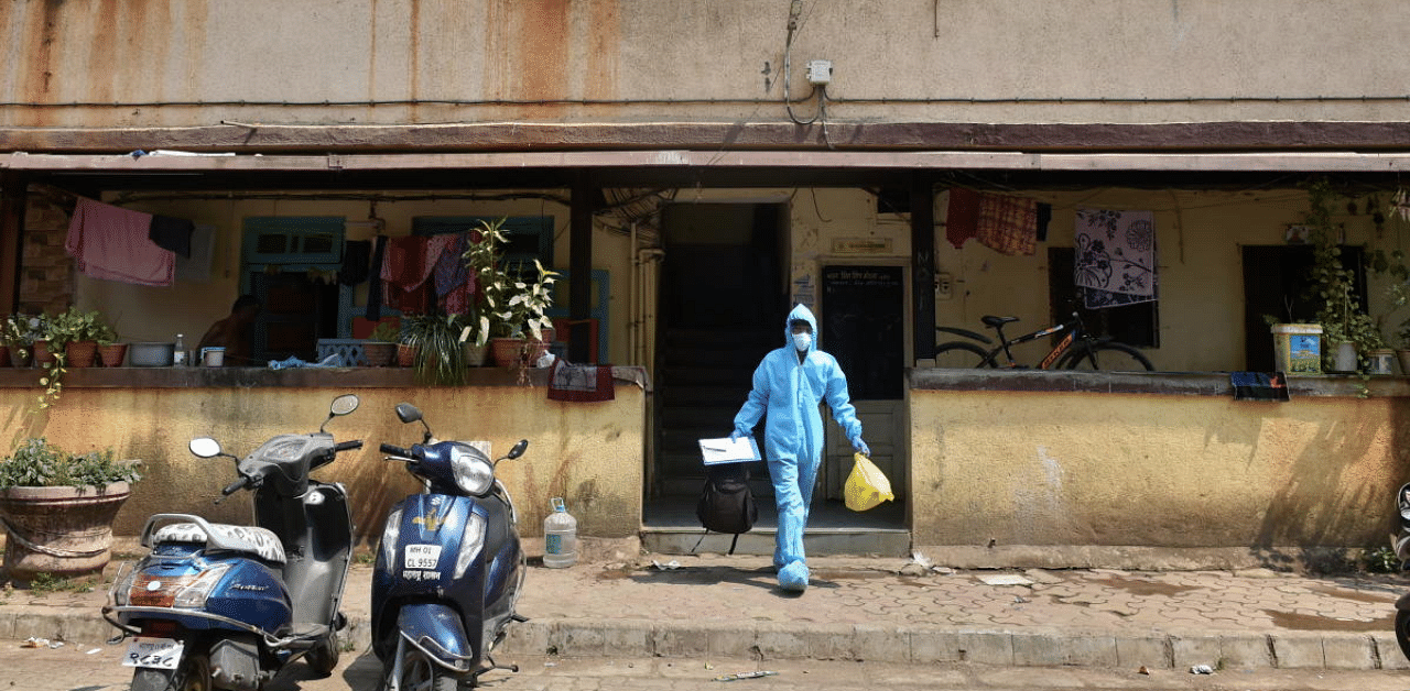 A health worker leaves a residential area after conducting swab tests for COVID-19 following rise in Corona cases at Dharavi, in Mumbai. Credit: PTI Photo