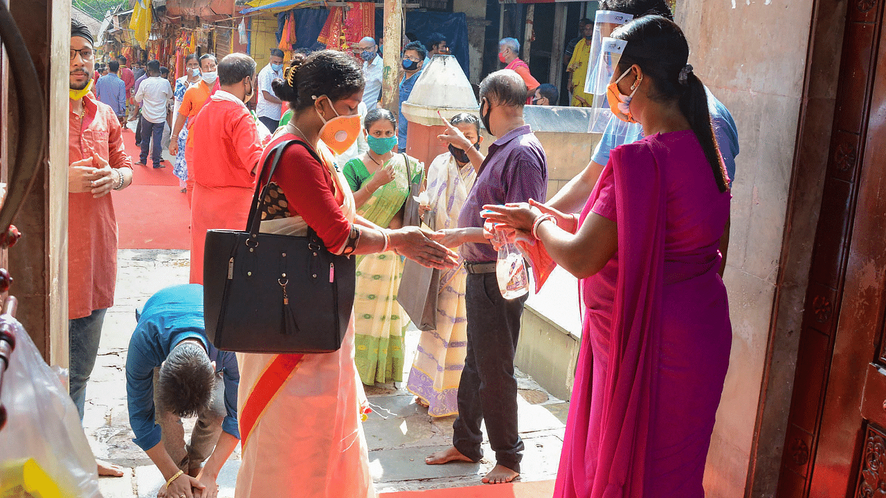 Devotees sanitise their hands inside the premises of Kamakhya Temple. Credits: PTI Photo