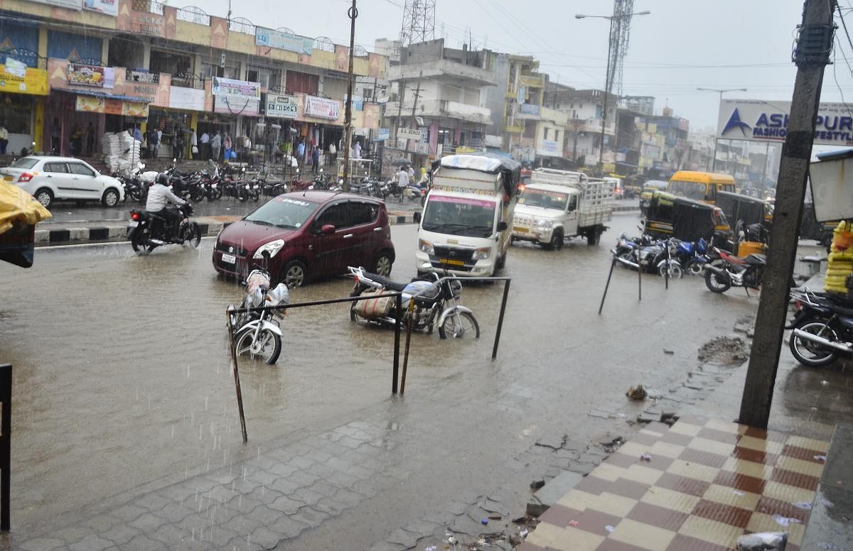 Motorists wade through the flooded Chittapur Road in Yadgir. The town experienced a four-hour-long downpour on Wednesday.