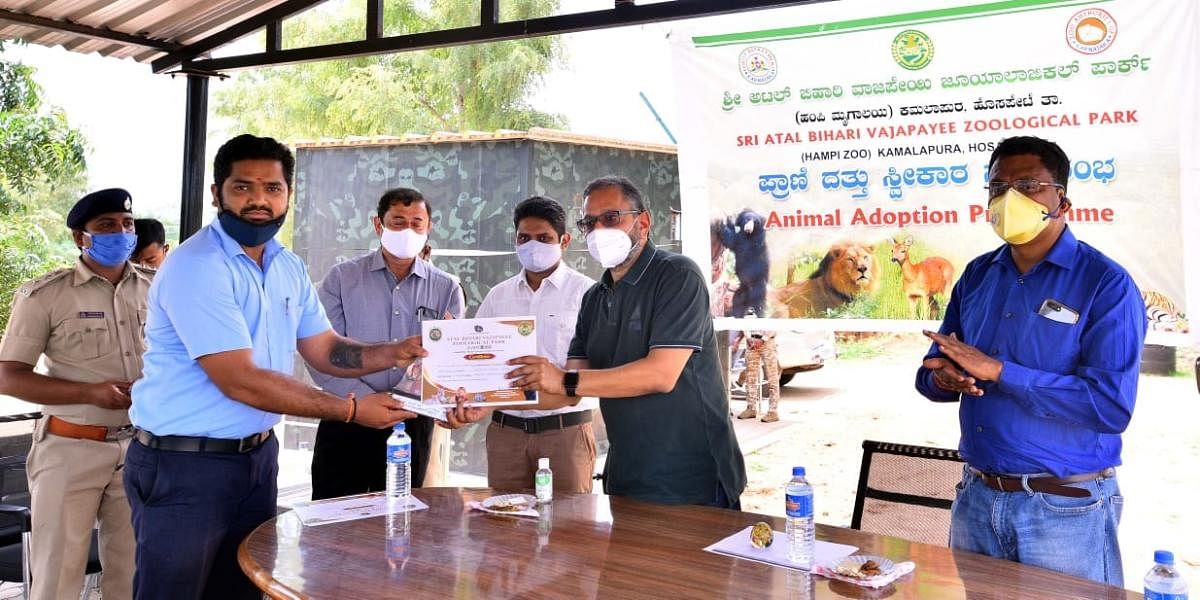 Sandeep Dave, additional chief secretary, Forest department, presents the animal adoption certificate to one of the adopters, at Atal Bihari Vajpayee Zoological Park in Hosapete taluk on Wednesday.