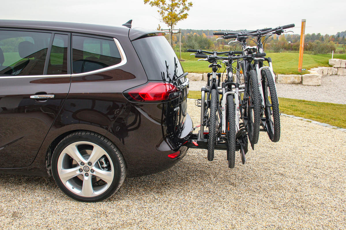 Folding bike holder behind a mini van. This rack can hold four bikes.