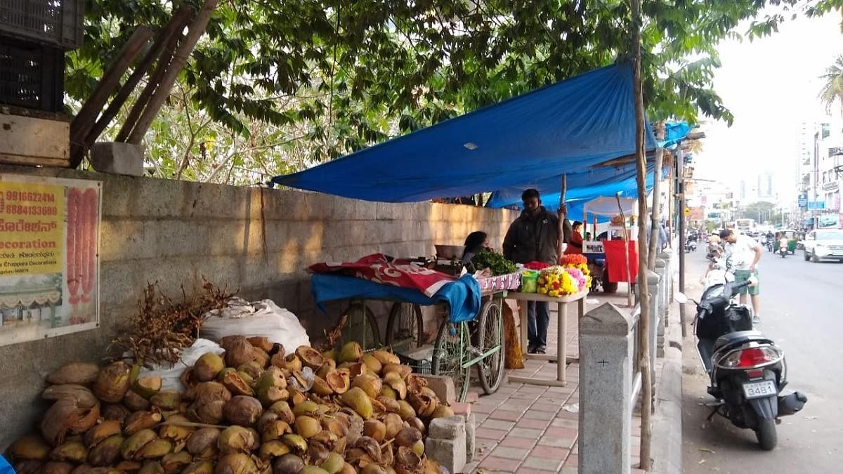 JP Nagar residents say the footpath is rendered useless due to encroachment by vendors.