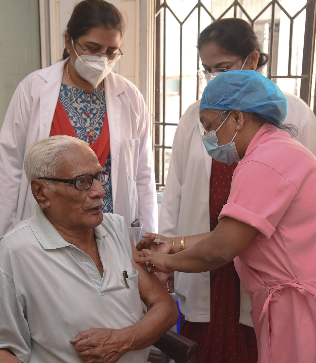 Medical staff at Jayanagar General Hospital administer the Covid vaccine to a senior citizen on Monday. Eighteen private hospitals in Bengaluru are authorised to provide the service.DH Photo by S K Dinesh