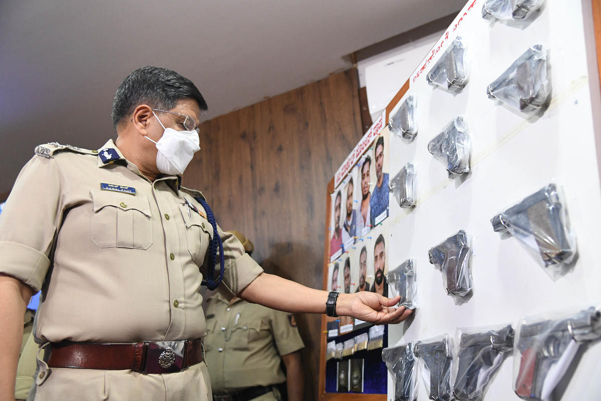 Bengaluru City Police Commissioner Kamal Pant inspects the pistols seized from the accused, on Monday. DH Photo/B H Shivakumar