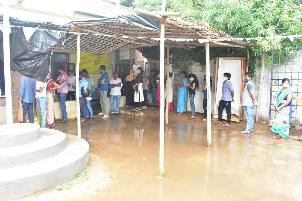 A file picture of people waiting in queue for Covid vaccination at a primary health centre in Hosapete. Credit: DH Photo