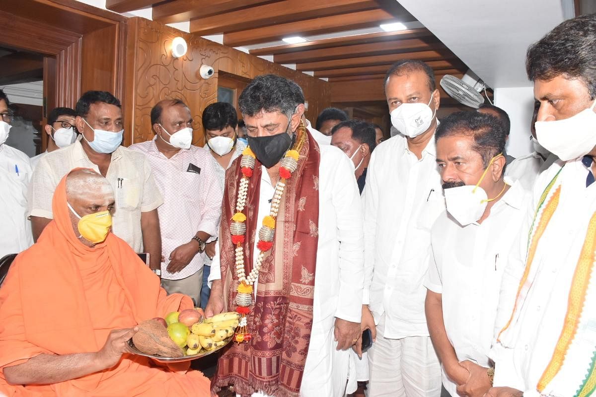 KPCC president D K Shivakumar seeks the blessings of Suttur seer Shivaratri Deshikendra Swami in Mysuru on Tuesday. MLC R Dharmasena, ex-MP R Dhruvakumar and ex-MLA M K Somashekar are seen. DH Photo