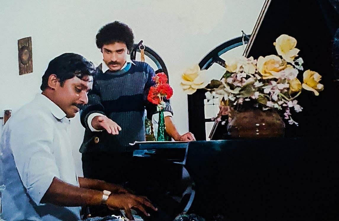 Hamsalekha presents a tune to Ravichandran on the sets of the film Bannada Gejje (1990).