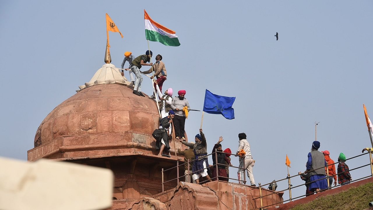 Farmers post flags on a dome of Red Fort after their tractor parade on Republic Day, in New Delhi, Tuesday, January 26, 2021. Credit: PTI Photo