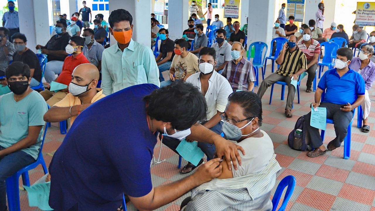 A health worker gives a dose of Covid-19 vaccine to a man at the premises of Everwin Matriculation School in Chennai, Thursday, May 20, 2021. Credit: PTI Photo