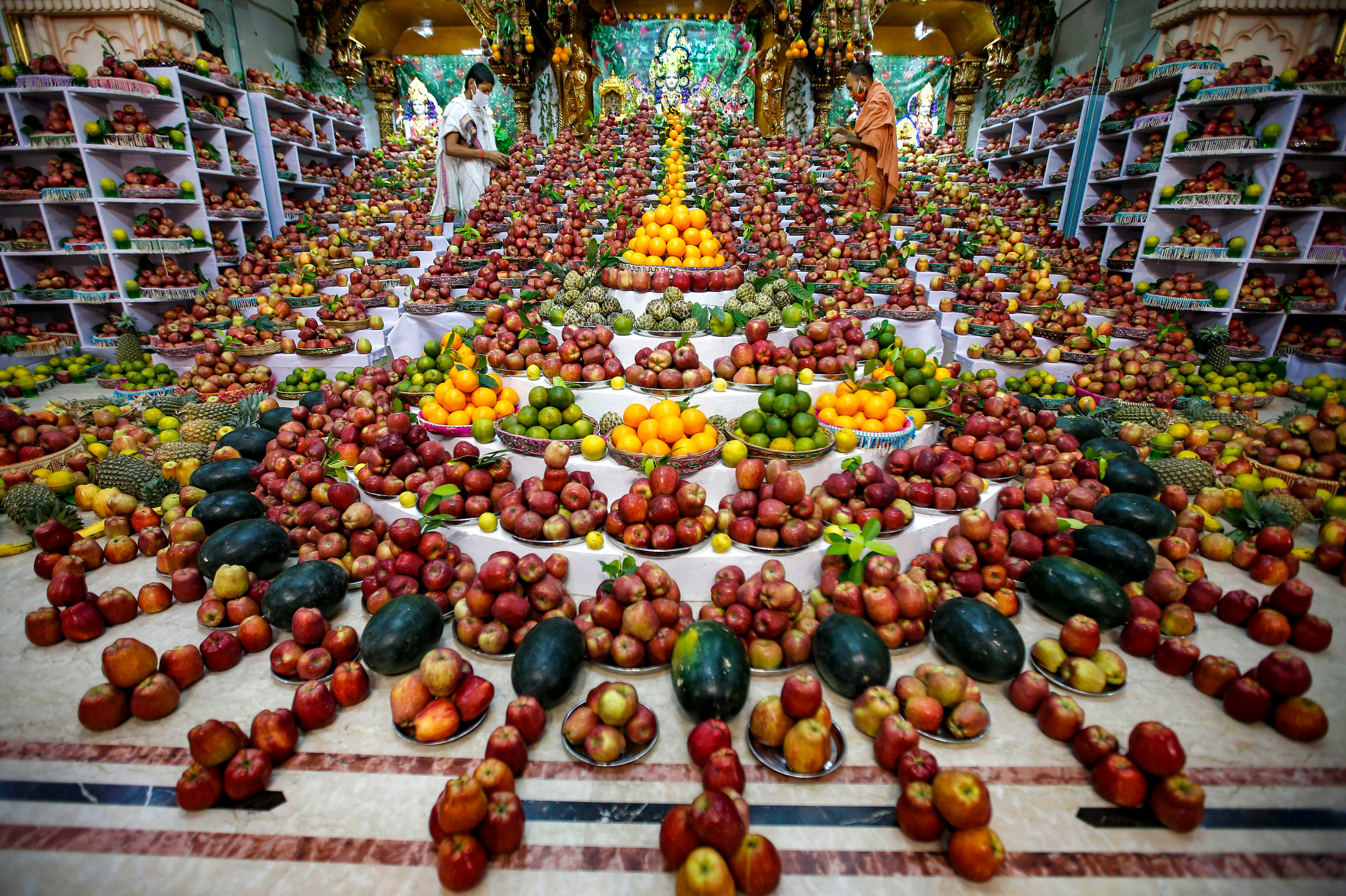A Hindu priest arranges sweets and fruits, kept as offerings by devotees as part of a ritual to mark 'Annakut' festival , at a temple in Ahmedabad, Tuesday, Oct. 13, 2020. Credit: A Hindu priest arranges sweets and fruits, kept as offerings by devotees as part of a ritual to mark 'Annakut' festival , at a temple in Ahmedabad, Tuesday, Oct. 13, 2020. Credit: PTI PhotoPTI Photo