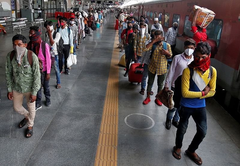 Migrant workers and their families, who had left during a lockdown, walk at a platform after they returned from their home state of Uttar Pradesh. Credits: Reuters Photo