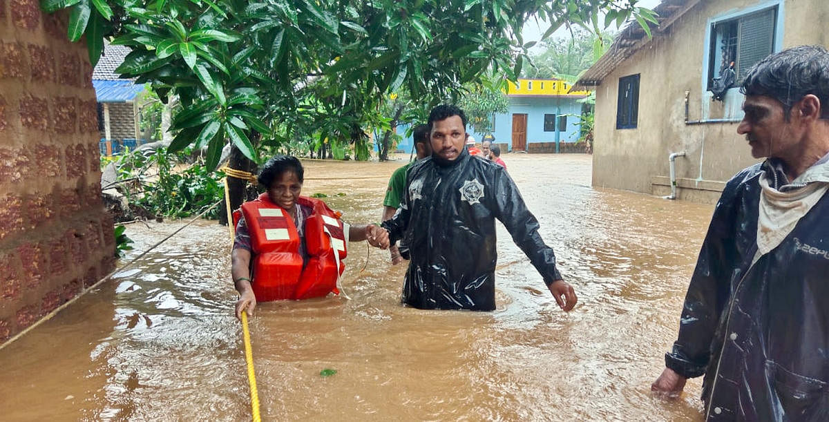 Firefighters and the police personnel evacuate the residents of marooned Avarsa village in Ankola taluk, Uttara Kannada, on Thursday. The overnight downpour has turned many villages in Ankola and Karwar taluk into islands. DH PHOTO