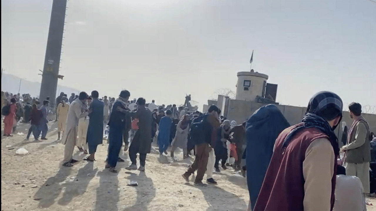 People gathered outside the airport react to gunfire, in Kabul, Afghanistan. Credit: Reuters Photo