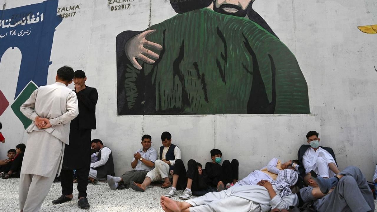 People sit near the French embassy in Kabul on August 18, 2021 following the Taliban stunning takeover of Afghanistan. Credit: AFP Photo