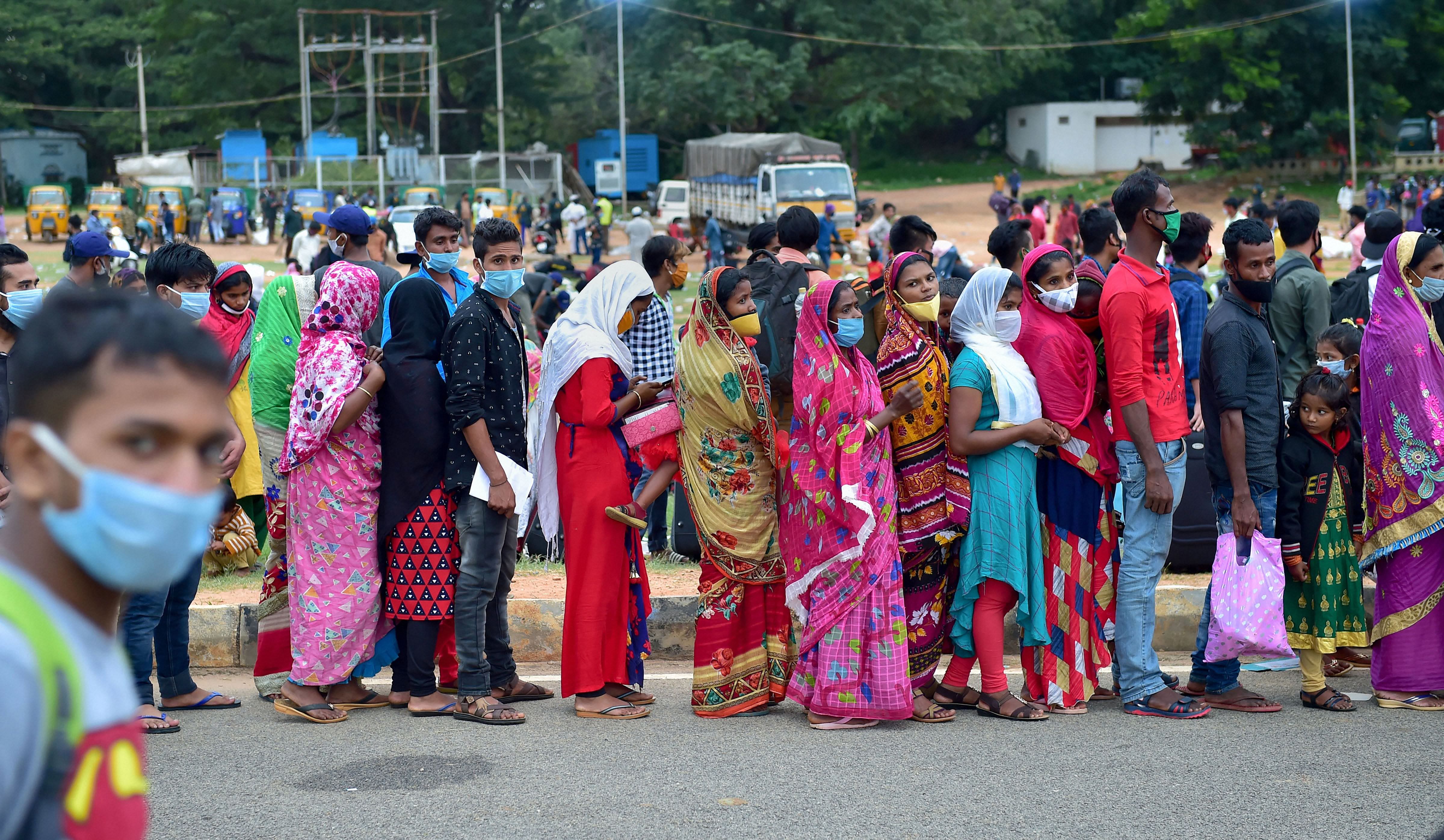 Migrants stand in queues at Palace Ground for their onward journey to their native places via 'Sharmik Special' train, during the ongoing COVID-19 nationwide lockdown, in Bengaluru. Credits: PTI Photo