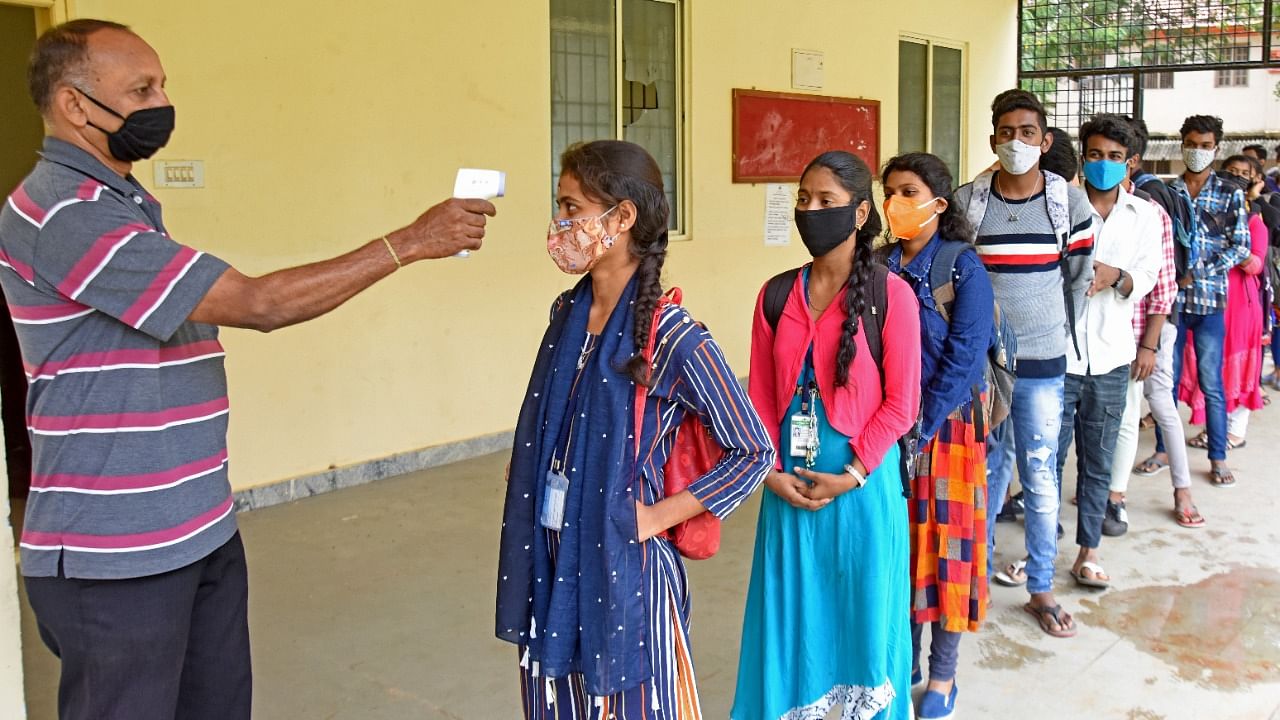 Students undergoing thermal scanner check at a government degree college in Bengaluru. Credit: DH File Photo