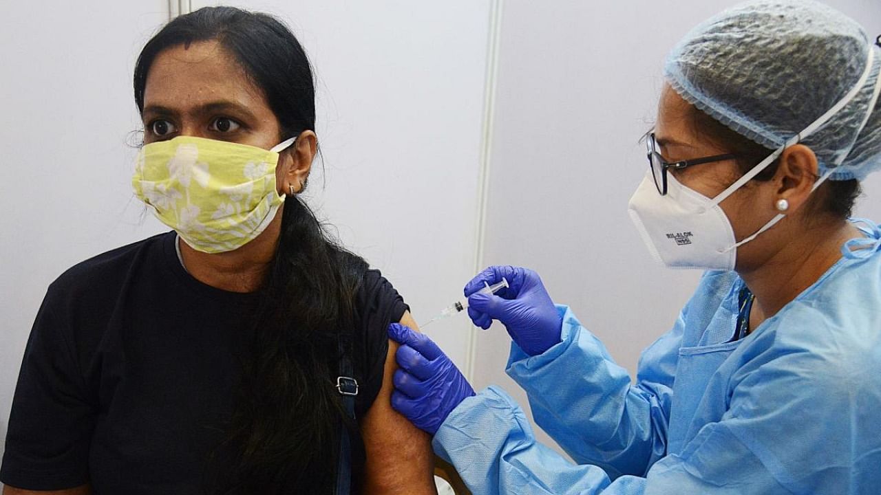 A health worker inoculates a woman with a dose of the Covaxin vaccine against the Covid-19 coronavirus at Dr. Antonio Da Silva High School in Mumbai. Credit: AFP Photo