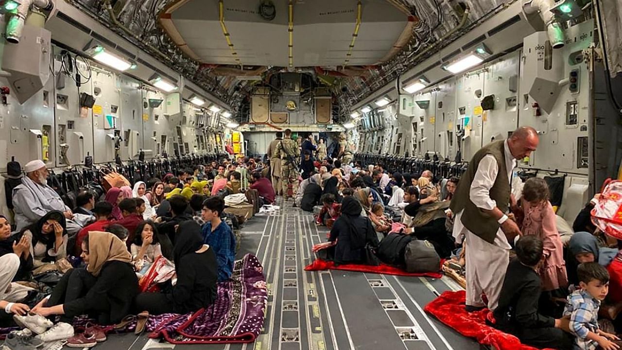 Afghan people sit inside a U S military aircraft to leave Afghanistan, at the military airport in Kabul on August 19, 2021 after Taliban's military takeover of Afghanistan. Credit: AFP Photo